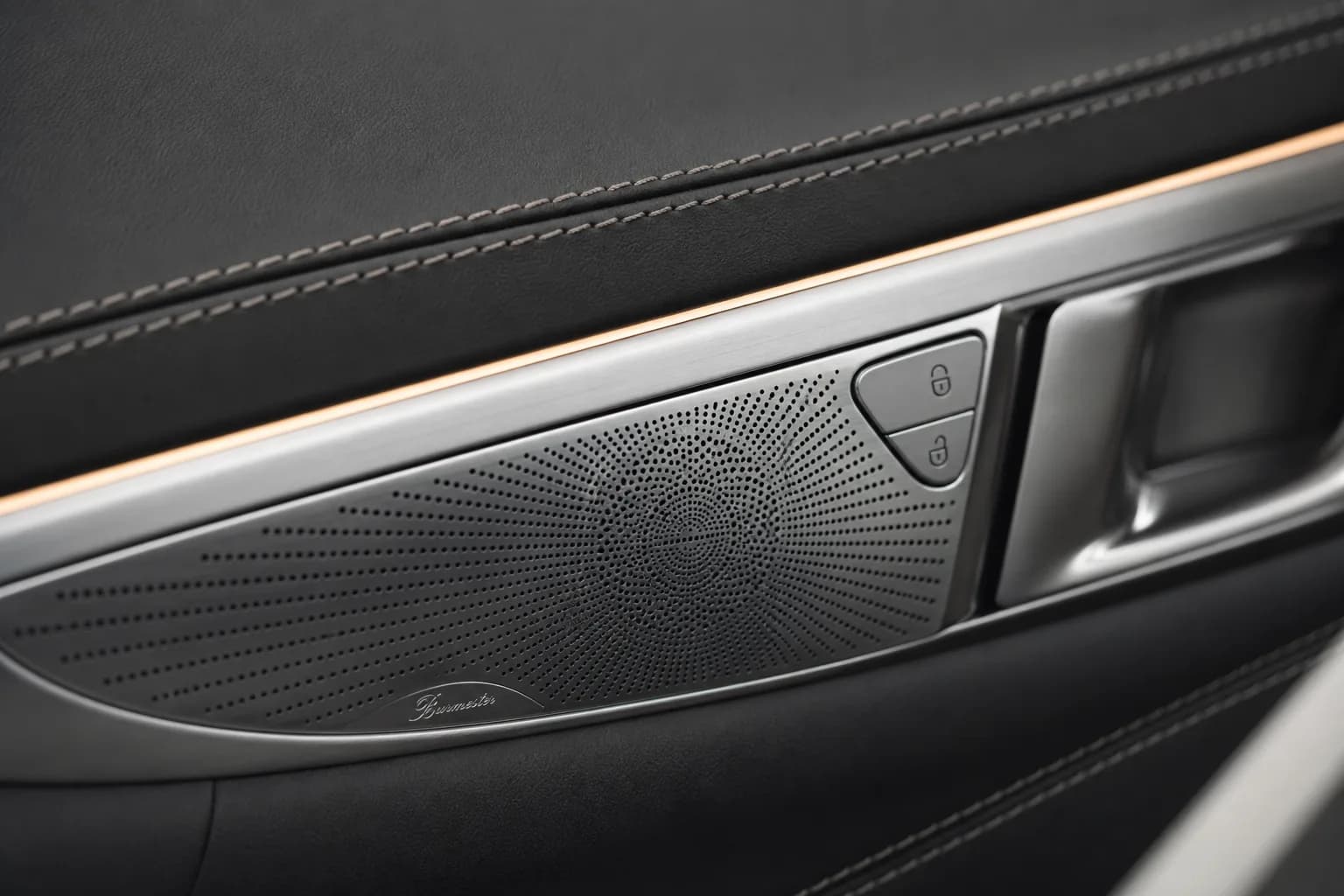 Close-up of leather stitching and a premium sound system detail inside the vehicle